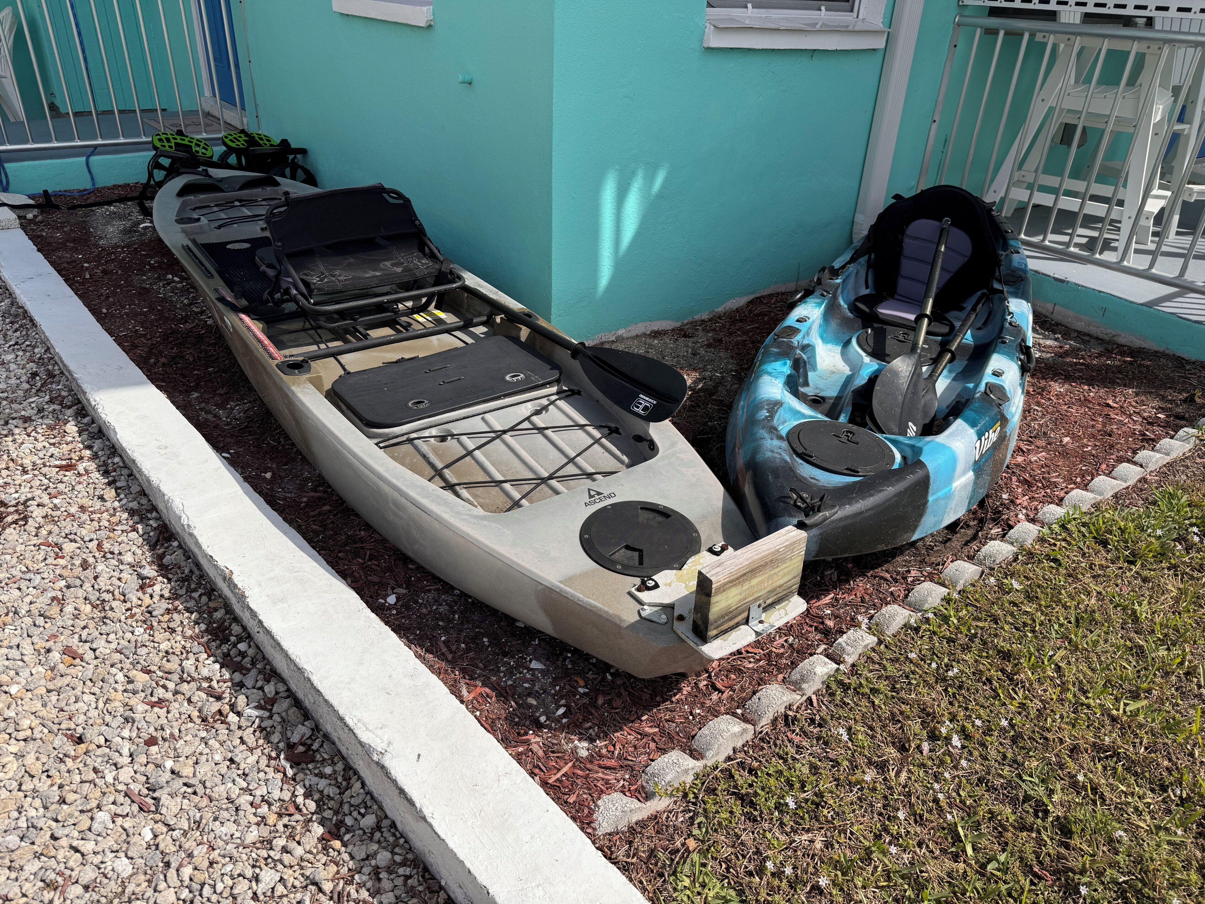 Two kayaks and a paddleboard docked at a waterfront property.