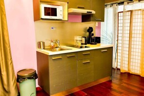 A compact kitchen with a microwave, sink, and cabinets. - Charming Mini Loft in the Heart of the Historic Center (Bordeaux)