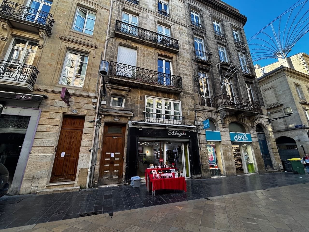 A street view with a boutique store named 'Magic' and a 'deux euros' shop.