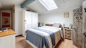 Une chambre à coucher comprenant un lit, une armoire, un bureau et une commode.
