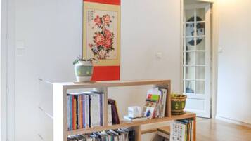 A room with a bookshelf, a potted plant, and a door leading to another room.