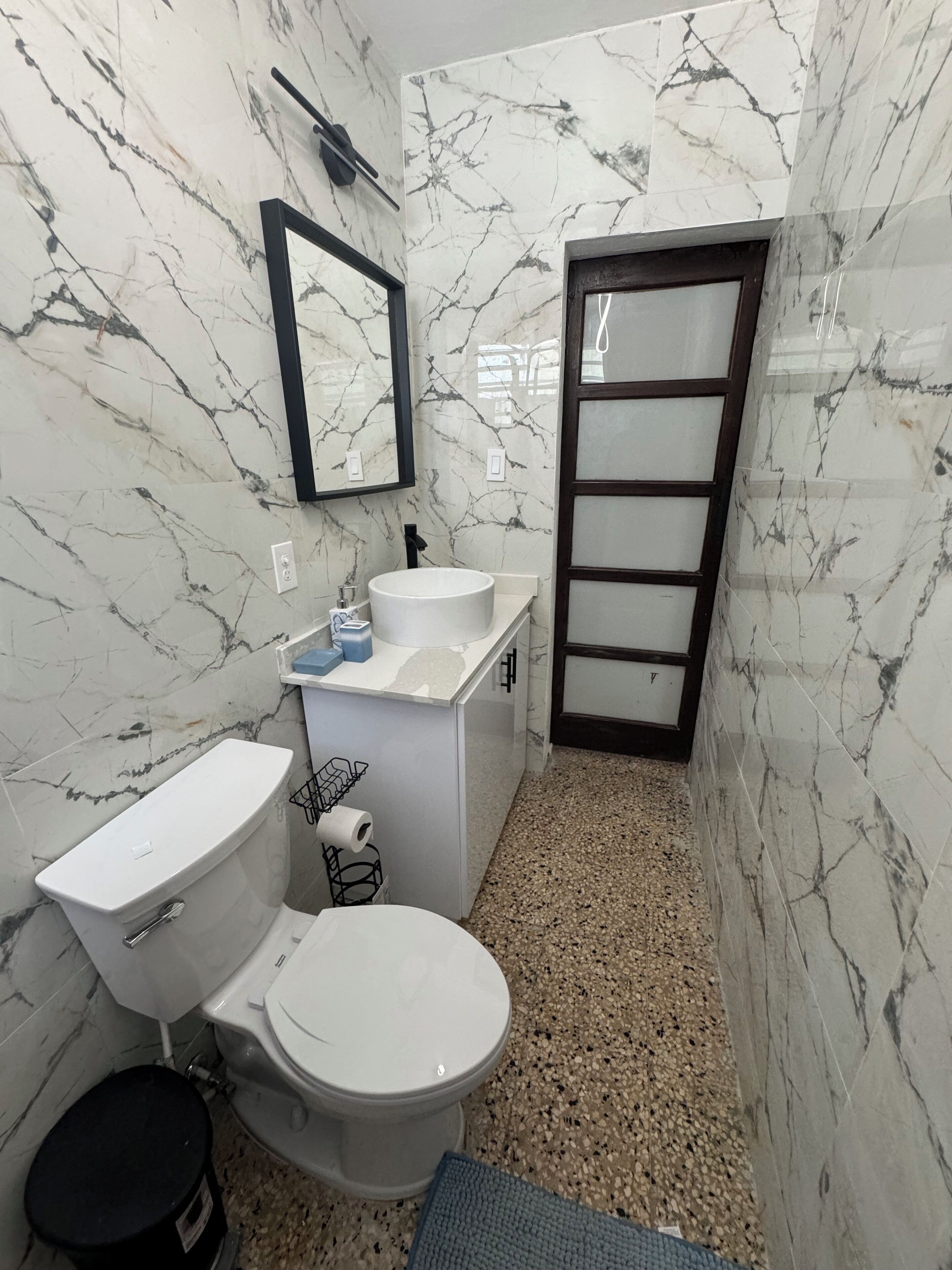 Une petite salle de bain comprenant des toilettes, un lavabo et un miroir.