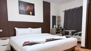 A neatly made bed with white linens in a hotel room. - Azure Palace (Patong)