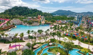 A resort with multiple swimming pools, water slides, and a large rock formation. - Azure Palace (Patong)