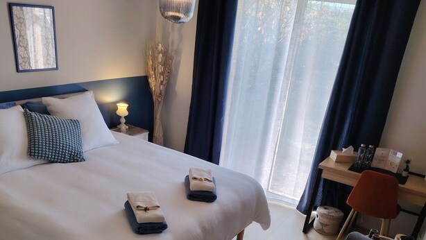 Quarto de hotel moderno com uma cama grande, uma escrivaninha e uma cadeira.