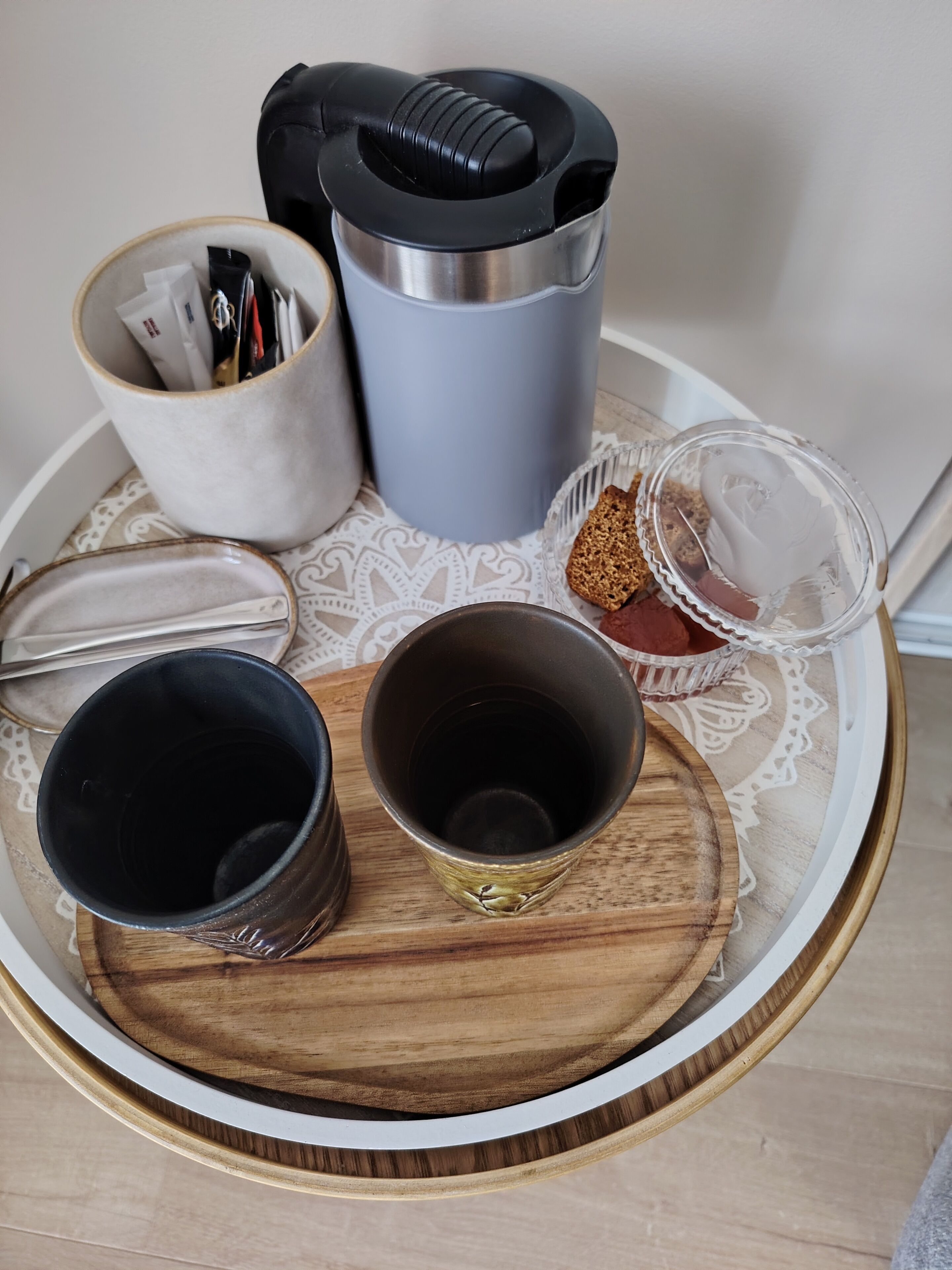 Un plateau contenant divers récipients, notamment un thermos, une tasse et un bocal en verre.