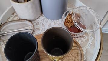 Un plateau contenant divers récipients, notamment un thermos, une tasse et un bocal en verre.