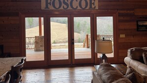Un interior de madera con un letrero que dice "FOSCOE" sobre un conjunto de puertas de vidrio que dan a una terraza al aire libre.