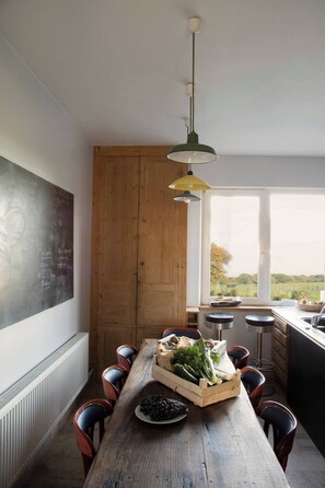 A kitchen with a wooden table, chairs, a chalkboard, and a window with a view. - Elegant Normandy Country House – 5 Minutes from the Sea (Ouainville)
