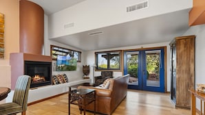 A spacious living room with a fireplace, a sofa, a coffee table, and a TV. - 2 bed 2 bath in the Kayenta Art Village W/Views of the red rock cliffs. (Ivins)