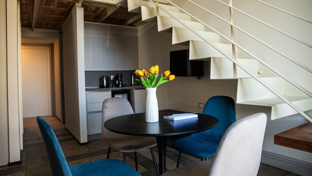 Een moderne leefruimte met een eethoek, een keuken en een trap.