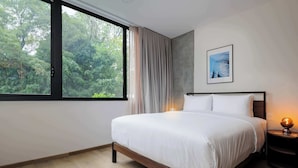 A bedroom with a large window, a bed, a nightstand, and a framed picture on the wall. - w* | Sophisticated 3BR in the Heart of Cuauhtemoc (Ciudad de México)