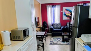 A compact living space with a kitchenette, a dining area, and a seating area. - Stunning Ocean, City & Pool View 2 Bedroom Apt. 2 minutes from Roseau (Roseau)