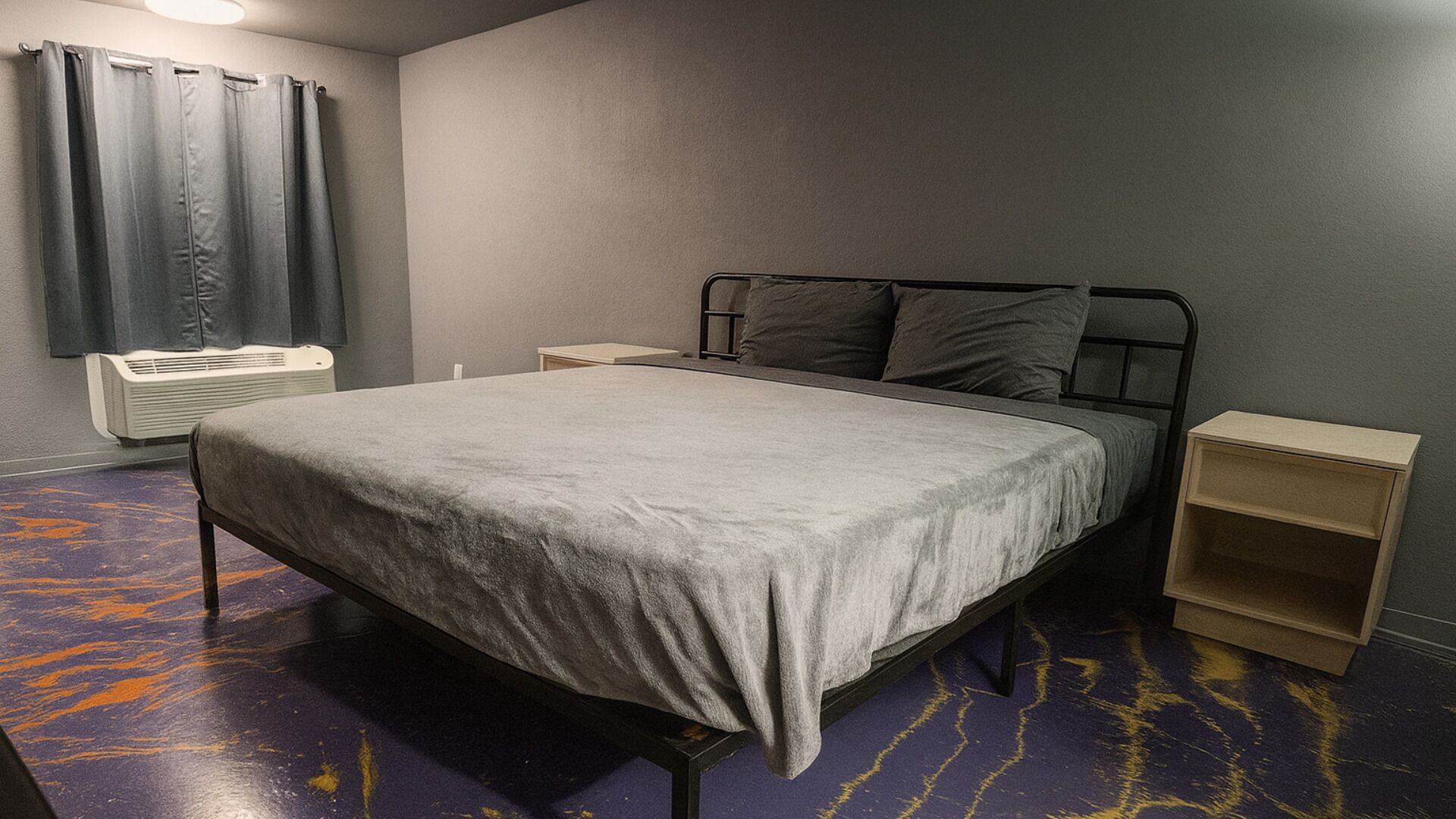 Ein Schlafzimmer mit Bett, Nachttisch, Heizung und Vorhang.