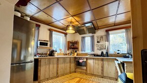 Une cuisine avec des meubles en bois, un réfrigérateur en acier inoxydable, un four à micro-ondes et une cuisinière.