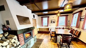 Une pièce chaleureuse avec une cheminée en pierre, des meubles en bois et des rideaux à carreaux.