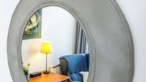 A round mirror with a concrete-like frame on a white wall. - Cosy, bright 68m2 apartment in the center of town (Boulogne-sur-Mer)