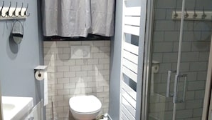 Un baño con inodoro, ducha y lavamanos.