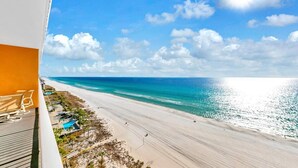 Un balcon avec vue sur une plage et l’océan.