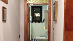 A narrow hallway leading to a bathroom with a sink and a window. - Apartment in Villa Jolanda (Romano d'Ezzelino)