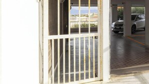 A gated parking area with a white car parked inside. - Cagliari panoramic view by Propertize (Cagliari)