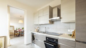 A modern kitchen with a built-in washing machine, oven, and a stainless steel sink. - Cagliari panoramic view by Propertize (Cagliari)