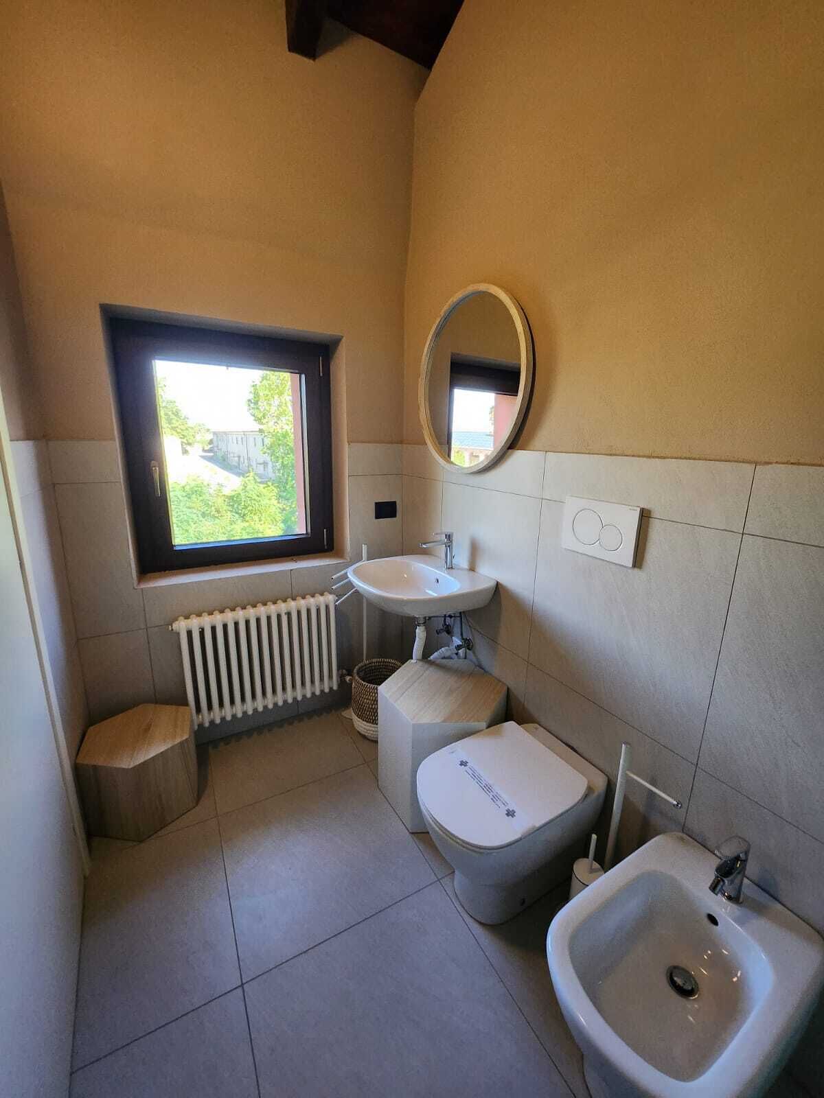 Une petite salle de bain avec une fenêtre, un lavabo, un bidet et des toilettes.