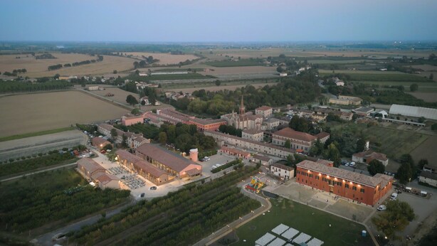 An aerial view of a historic town with a central church, surrounding buildings, and open fields. - Agriturismo Pizzavacca (Villanova sull'Arda)