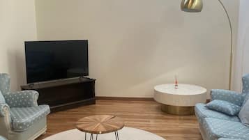 Deluxe Quadruple Room, Patio | Living area | Computer monitors