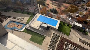 An aerial view of a residential area with a rooftop pool, green spaces, and surrounding buildings. - Apartament H&C (Madrid)