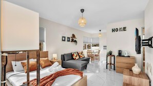 Habitació d'hotel moderna amb un llit, un sofà i una zona de menjador.