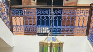 A multi-level interior with a central seating area, ornate railings, and a hanging lantern. - 3-bedroom Riad in enchanting Marrakech, Wifi and Pool (Marrakech)