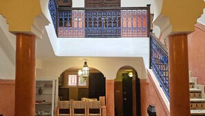 A spacious interior with a high ceiling, a central fountain, and a staircase leading to an upper level. - 3-bedroom Riad in enchanting Marrakech, Wifi and Pool (Marrakech)