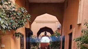 A narrow alleyway with arches, a brick wall, and potted plants. - 3-bedroom Riad in enchanting Marrakech, Wifi and Pool (Marrakech)