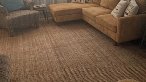 A living room with a beige sectional sofa, patterned armchair, and a small side table. - Lake Life for Two -Walk to Marina + Close to Beach (Lakeview)