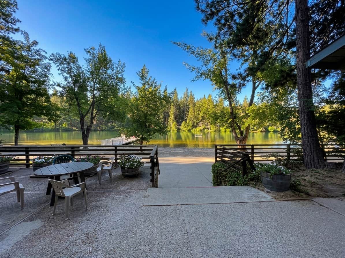 A lakeside patio with outdoor seating and a view of the lake.