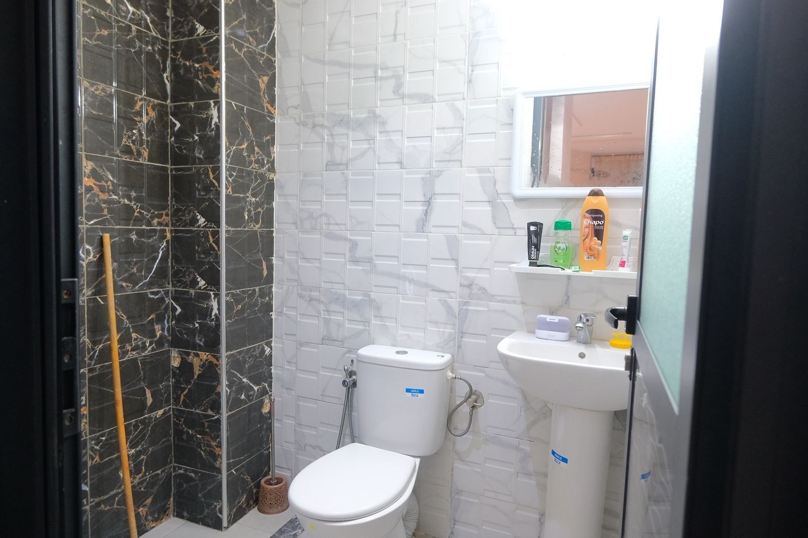 Une salle de bain comprenant des toilettes, un lavabo et un espace douche.