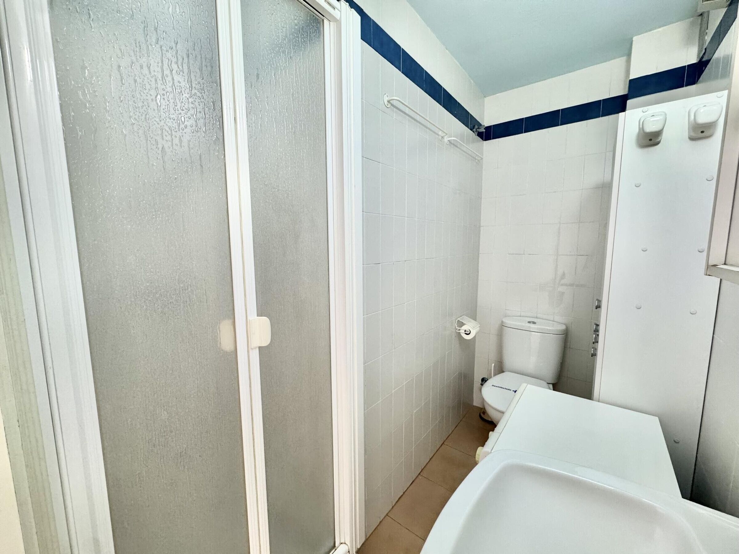 A bathroom with a shower, toilet, and bathtub.