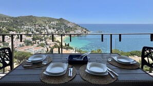 A table set for four with a view of a coastal town and the sea. - Apartment in Roses with terrace, private parking, and equipped kitchen (Roses)