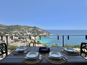 Ein Tisch für vier Personen mit Blick auf eine Küstenstadt und das Meer.
