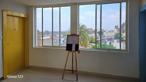 A room with large windows, a yellow door, and a menu board. - Hotel Sunset Orchha (Orchha)