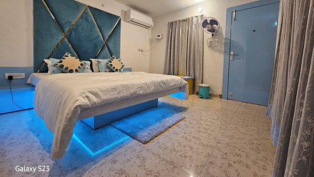 A modern bedroom with a bed, air conditioning unit, and a fan. - Hotel Sunset Orchha (Orchha)