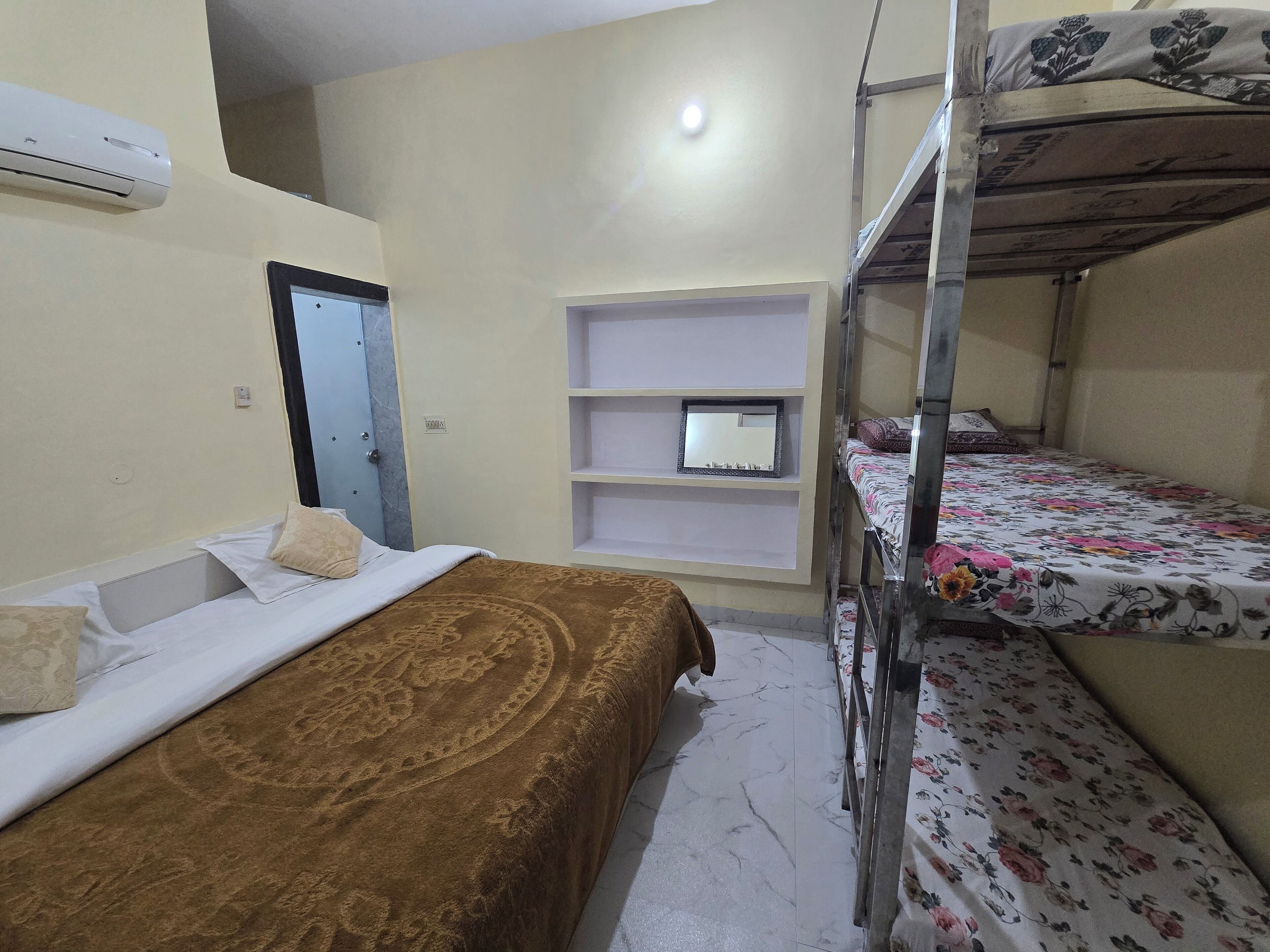 Un dormitorio con literas, una mesita de noche, un espejo y una estantería.