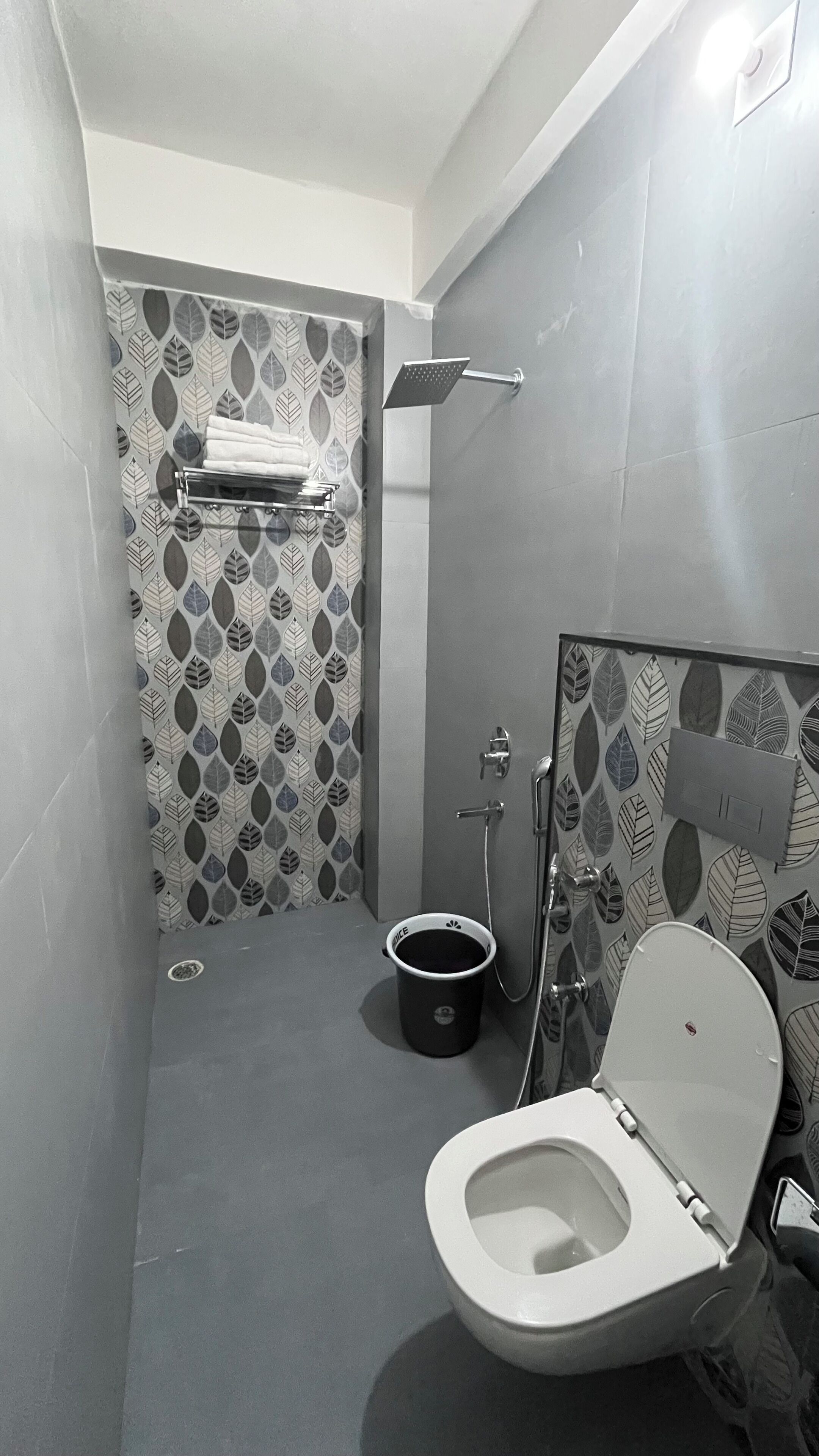 Une petite salle de bain comprenant des toilettes, une douche et un lavabo.