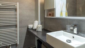 A modern bathroom with a white sink, a towel rack, and a mirror. - Ski-in/ski-out apartment for families with balcony and parking (Courchevel 1650)