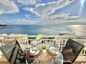 Un balcone con un tavolo apparecchiato per due, con vista sulla costa.