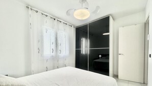 Un dormitorio moderno con cama, armario y baño.