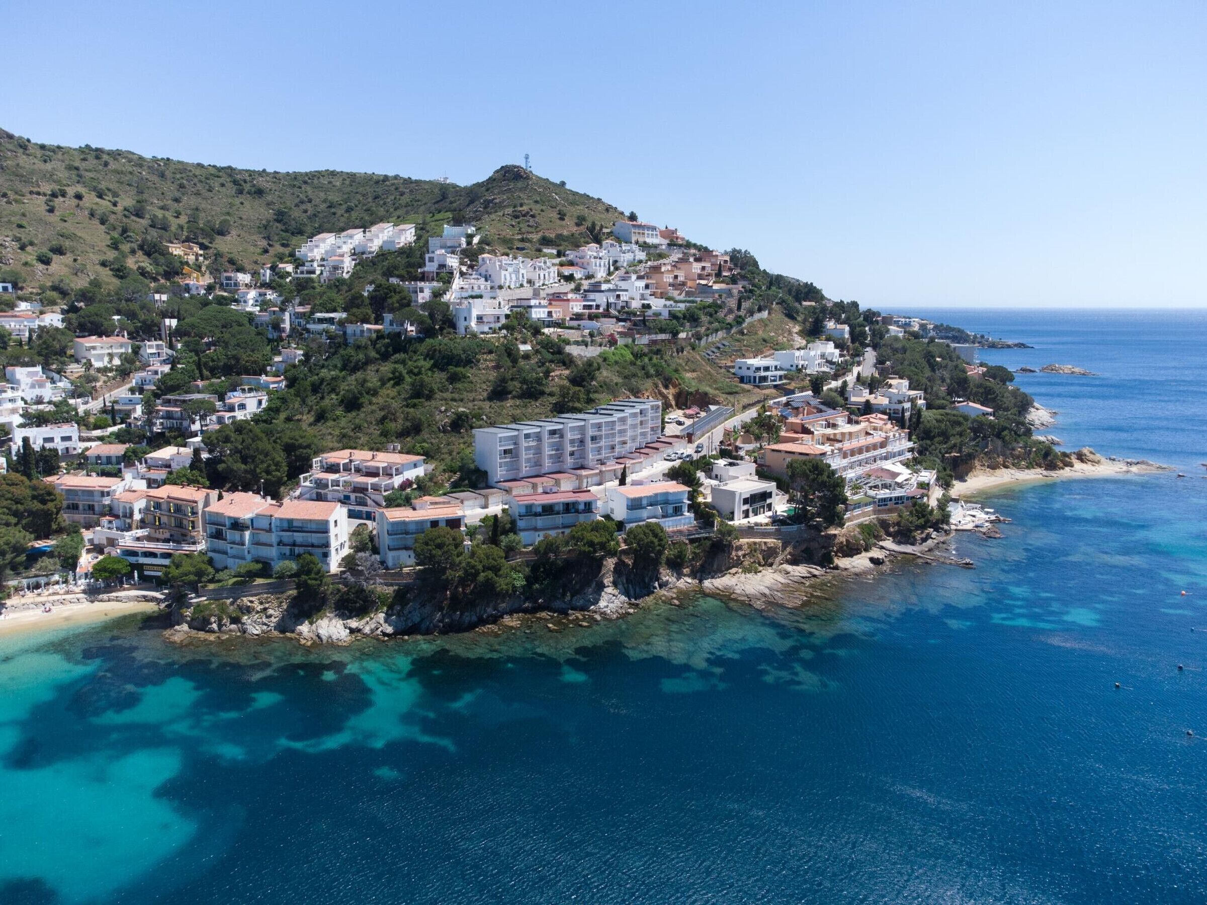 A coastal town with buildings on a hillside overlooking the sea.