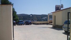 A parking area with several cars, a satellite dish, and a mountainous backdrop. - Apartment with pool, AC, and parking 700m from the beach in Roses (Roses)