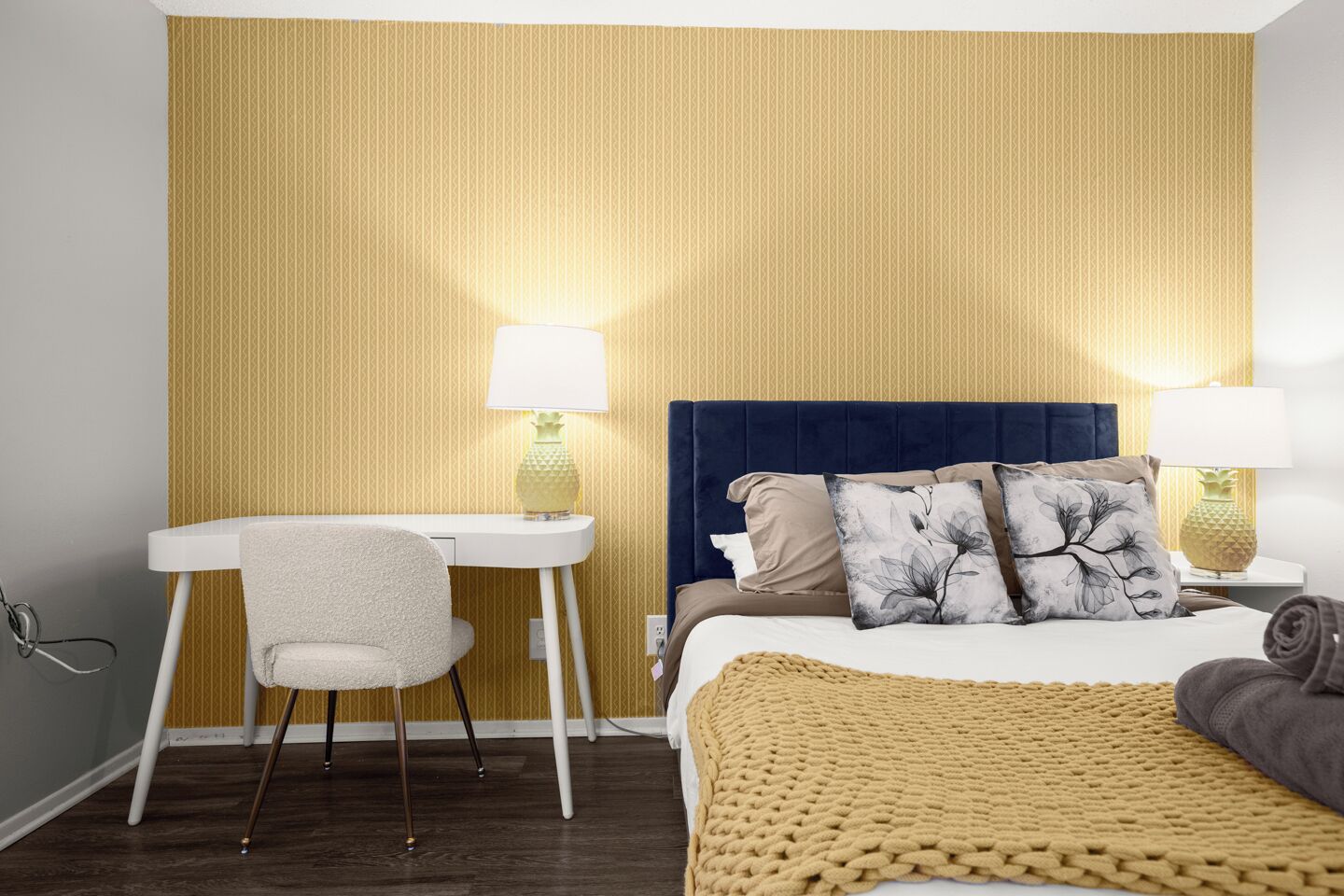 Une chambre d’hôtel avec un lit, un bureau et deux lampes.